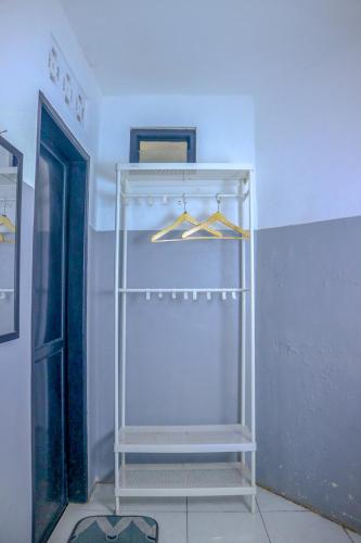 a white rack with hangers in a room at 360 Homestay Padang in Kampungdurian