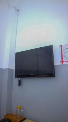a flat screen tv hanging on a wall at 360 Homestay Padang in Kampungdurian