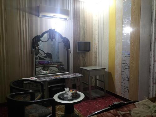 a room with a mirror and a table and a tv at Kingston Motel in Lahore