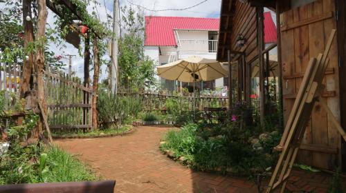 un patio con una sombrilla junto a una valla en Sun Homestay Mang Den, en Kon Von Kla
