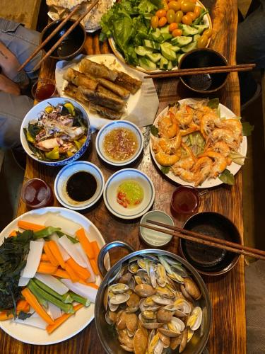 une table avec de nombreuses assiettes de nourriture dans l'établissement Sun Homestay Mang Den, à Kon Von Kla