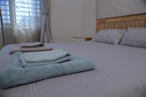 a bedroom with two beds with towels on them at Lion King Mufasa in Mukono