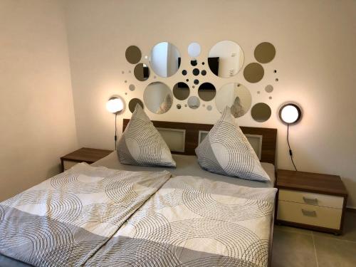 a bedroom with a bed with two pillows and mirrors on the wall at Erdgeschoss-Appartement mit Seeterasse in Ahrensbök