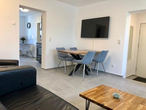 a living room with a table and chairs and a tv at Erdgeschoss-Appartement mit Seeterasse in Ahrensbök