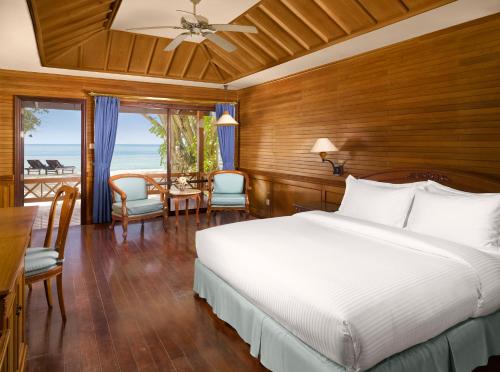 a bedroom with a bed and a view of the ocean at Royal Island Resort at Baa Atoll Biosphere Reserve in Baa Atoll