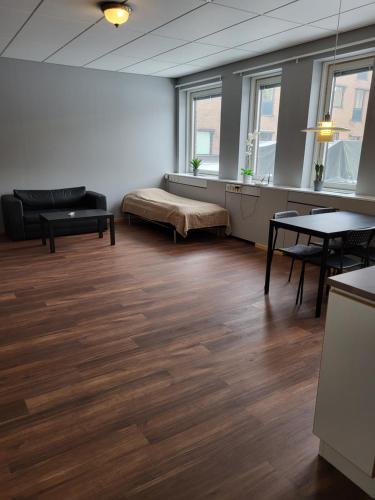 Großes Zimmer mit einem Bett, Tischen und Fenstern in der Unterkunft Apartments Centralstation in Uppsala