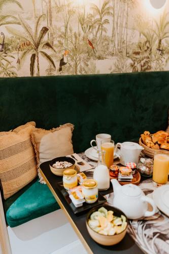 a table with breakfast foods and drinks on it at Palm Boutique Hôtel Nice in Nice