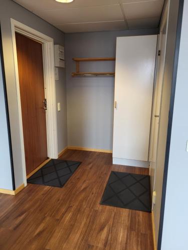 an empty room with a door and wood floors at Apartments Centralstation in Uppsala