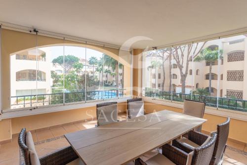 una mesa y sillas en una habitación con ventanas grandes en Hacienda Playa, en Marbella