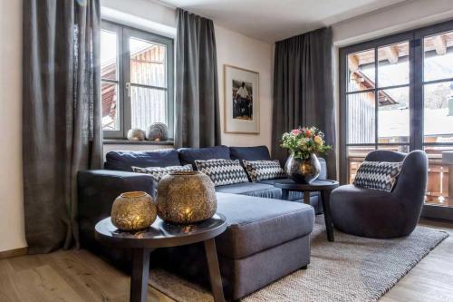 a living room with a blue couch and chairs at Fügenschuh's Ferienwohnungen in Bad Hindelang