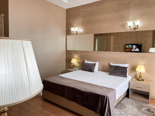 a hotel room with a bed and a mirror at NOBEL Hotel in Baku
