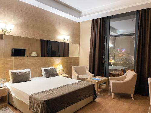 Habitación de hotel con cama y ventana grande en NOBEL Hotel en Baku