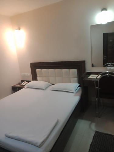 een slaapkamer met een bed, een wastafel en een spiegel bij VALA JANU HOTELS PVT LTD in Mumbai