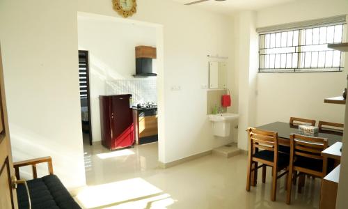 a kitchen and dining room with a table and chairs at Alite Enclaves Fully furnished apartments in Trichūr