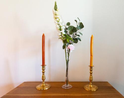 two vases with flowers in them on a table at Blå Dörren in Höör