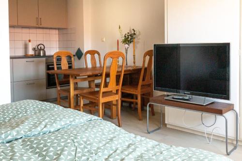 a kitchen with a table with chairs and a television at Blå Dörren in Höör