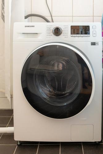 a white washing machine sitting in a kitchen at Blå Dörren in Höör