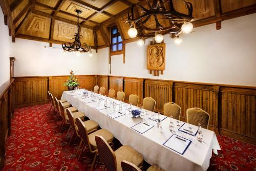 a conference room with a long table and chairs at Grand Hotel Praha in Tatranská Lomnica