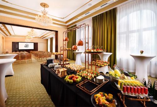 a buffet table in a hotel room with food on it at Grand Hotel Praha in Tatranská Lomnica
