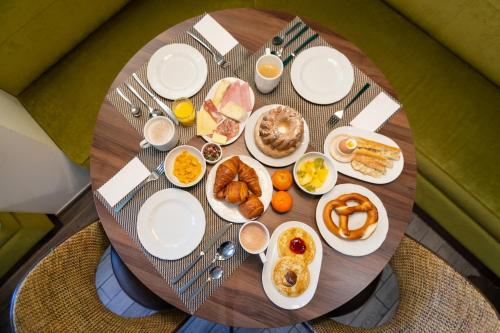 a round table with plates of breakfast foods on it at Hôtel Turenne in Colmar