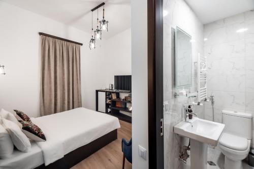 a white bathroom with a bed and a sink at VovaDoma in Tbilisi City