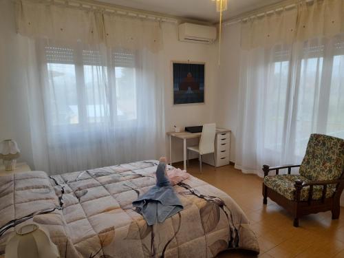 una camera con letto, sedia e finestre di CASA CAMELIA a Capannori