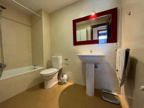 uma casa de banho com um lavatório, um WC e um espelho. em Duplex Bahía de Santoña em Santoña