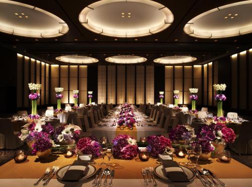 a banquet hall with a long table with purple flowers at Kyoto Tokyu Hotel in Kyoto