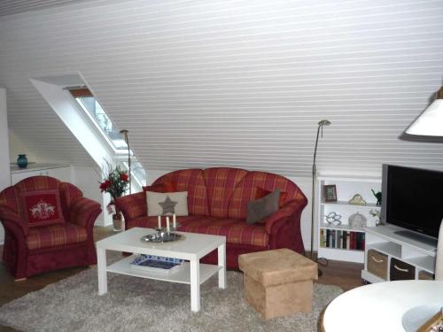 ein Wohnzimmer mit einem roten Sofa und einem TV in der Unterkunft Schuppe, Helga in Tarp