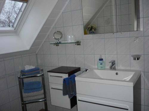 a white bathroom with a sink and a mirror at Gästehaus Schuppe in Tarp in Tarp