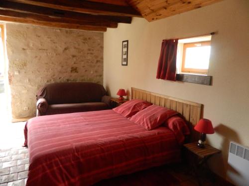 a bedroom with a bed and a chair and a window at Meublés de tourisme La Reserve in Saint-Pierre-les-Bois