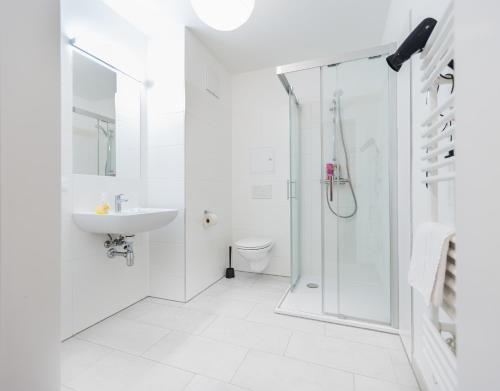 a white bathroom with a shower and a sink at Modern Apartment with free garage in Vienna