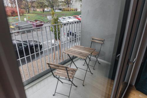 balkon ze stołem i krzesłami oraz widokiem na parking w obiekcie Modern Apartment with free garage w Wiedniu