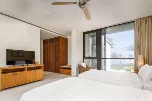 a bedroom with two beds and a flat screen tv at Villa seaview and apartment -Spa Da Nang Resort by JT group "Free pick up" in Da Nang