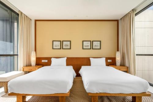 a hotel room with two beds and a window at Villa seaview and apartment -Spa Da Nang Resort by JT group "Free pick up" in Da Nang