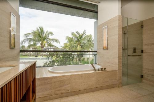 a bathroom with a tub and a large window at Villa seaview and apartment Da Nang by JT group in Da Nang