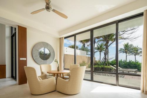 a living room with a table and chairs and a large window at Villa seaview and apartment -Spa Da Nang Resort by JT group "Free pick up" in Da Nang