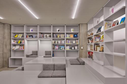 a living room with bookshelves and a library at Mangrove Sinseol in Seoul