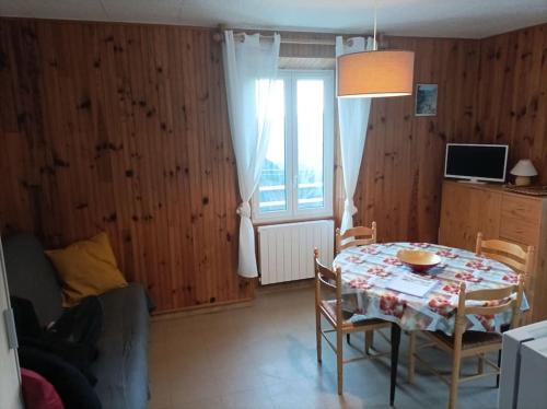 a dining room with a table and chairs and a window at 2 pièces proche cure thermale in Roquebillière