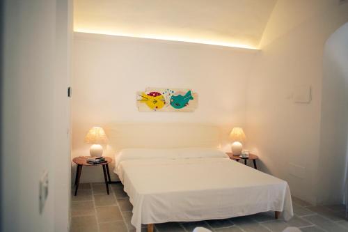 a white room with two beds and two lamps at dimore di portadibasso in Peschici