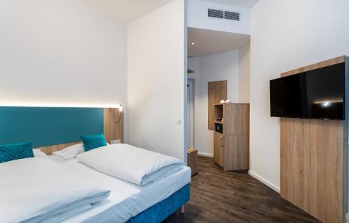 um quarto com uma cama e uma televisão de ecrã plano em DaunTown Rooms - Self Check-In em Viena