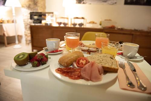 a table with plates of food and glasses of orange juice at El Petit Convent in Begur