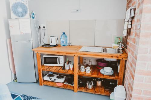 a kitchen with a counter with a microwave and a refrigerator at Rusthof Accommodation in Gansbaai