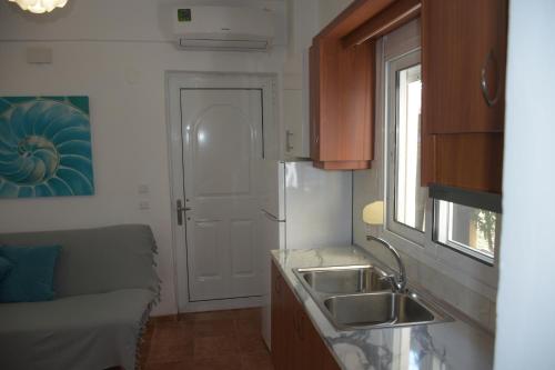 a kitchen with a sink and a couch and a window at Katerina's Apartment in Toroni