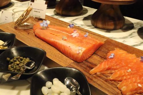 a cutting board with salmon and other foods on it at Suning Zhongshan Golf Resort in Nanjing