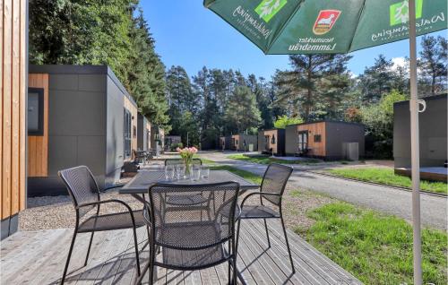 ein Tisch mit Stühlen und einem Sonnenschirm auf einer Terrasse in der Unterkunft Tiny Haus 37 Am Brombachsee in Pleinfeld