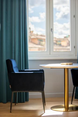 a chair and a table in a room with a window at Navona 49 Luxury Suites&Apartment in Rome