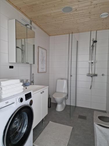a bathroom with a washing machine and a toilet at Huhta Sport in Jyväskylä