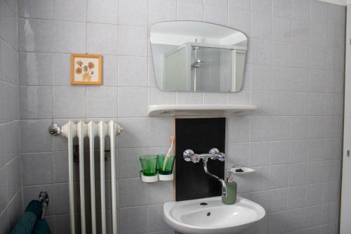 a bathroom with a sink and a mirror and a radiator at Wohnung mit Bergblick im Haus Sonne in Reith bei Seefeld
