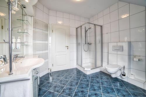 ein Bad mit einem WC, einem Waschbecken und einer Dusche in der Unterkunft Golfhotel Wagenfeld in Wagenfeld